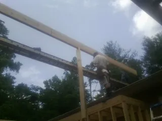 Carpenter setting a ridge beam over a new addition frame — Ice Dam Removal by Roofing Brothers in East Granby