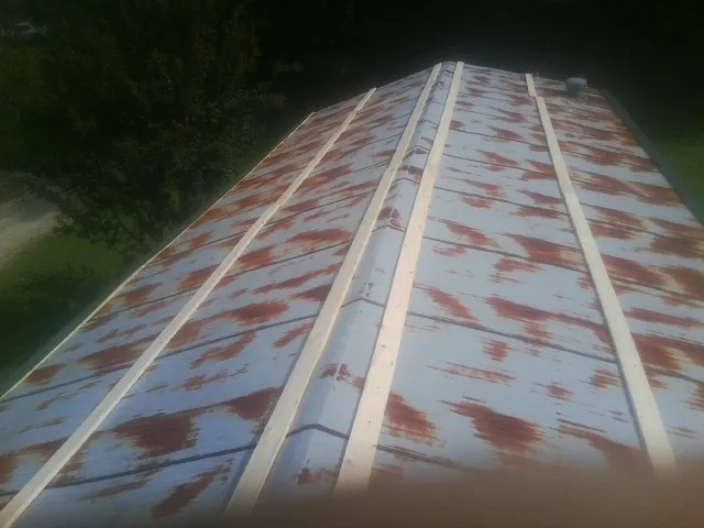 Rusted metal roof panels with new wood purlins before replacement — Storm Damage Roof Repair in East Granby by Roofing Brothers
