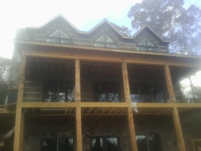 Dormers and porch framing on a large log home under construction — Roof Coating work by our crew in East Granby