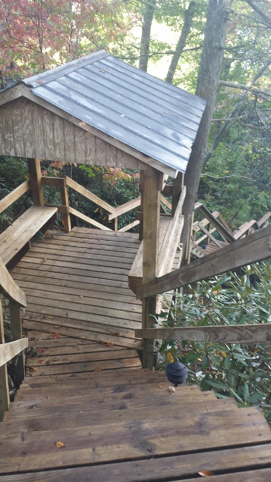 Metal roofed shelter over wooden steps on a wooded walkway — Skylight Repair & Installation work by our crew in East Granby
