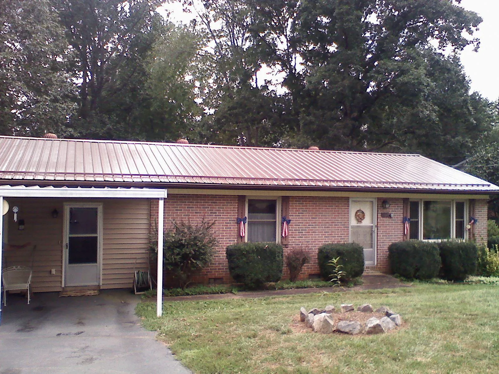 Bronze metal roof and carport on a brick ranch home — Roof Repair work by our crew in East Granby